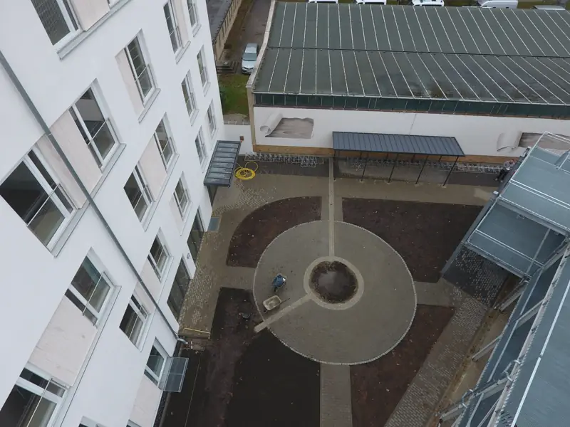 Gepflasterter Innenhof einer Wohnanlage aus der Vogelperspektive