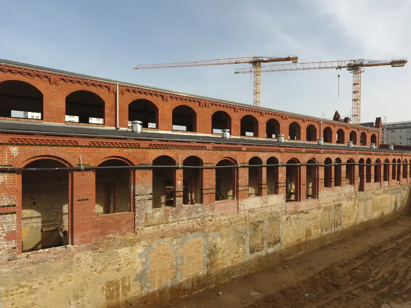 Erdarbeiten an einer denkmalgeschützten Backsteinhalle in Berlin