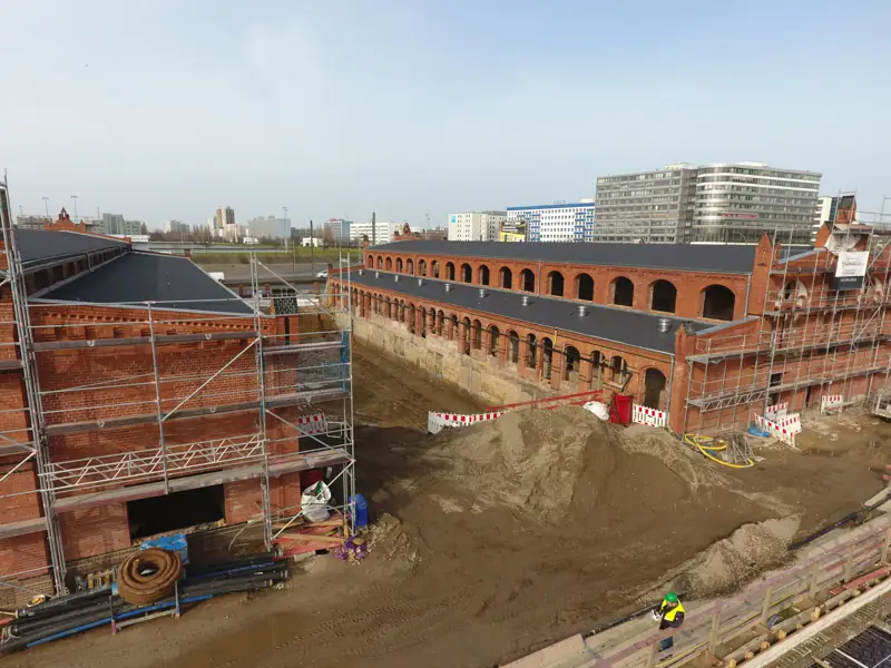 Erdarbeiten neben historischen Backsteinhallen in Berlin-Lichtenberg