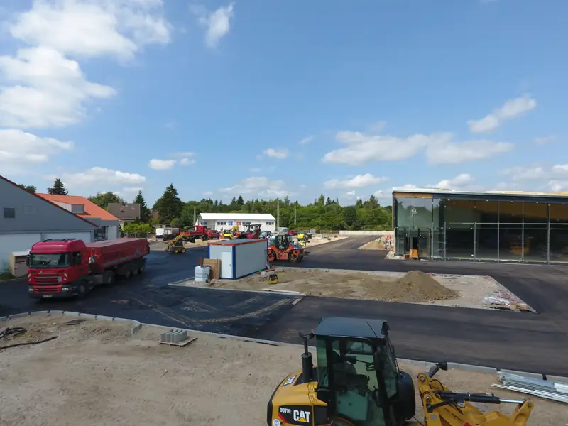Radlader auf einer Parkplatzbaustelle an einem Gewerbebau