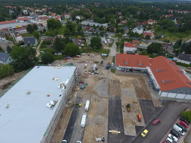 Luftbild eines neuen Gewerbebaus mit Parkplatzbau